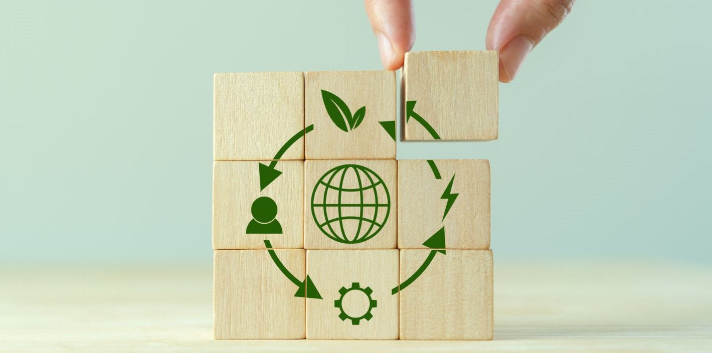 Wooden blocks assembling to form an illustration of a circular economy, representing sustainable practices at Bee Dee Bags.